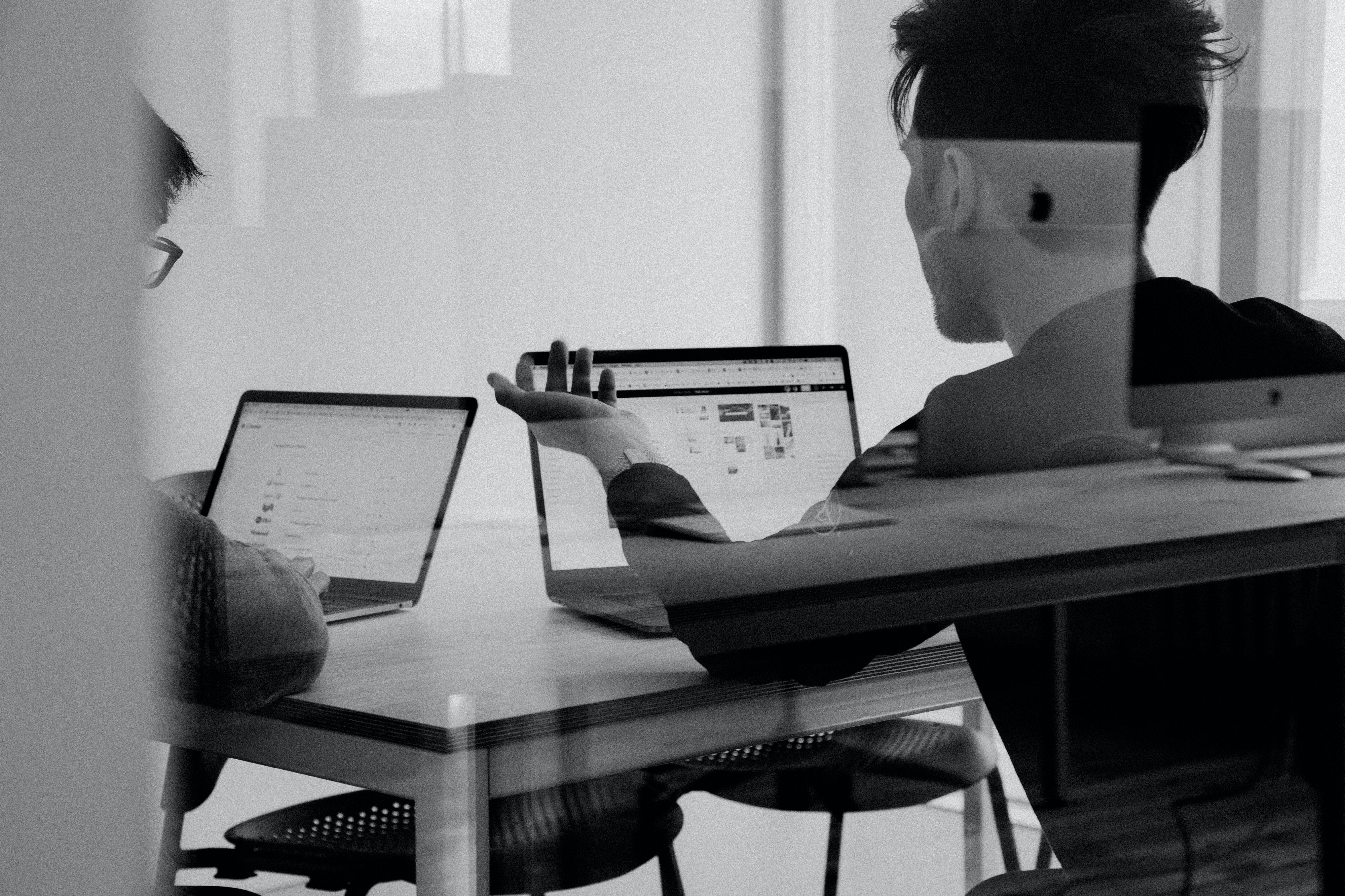 Two people working at their computers in black and white